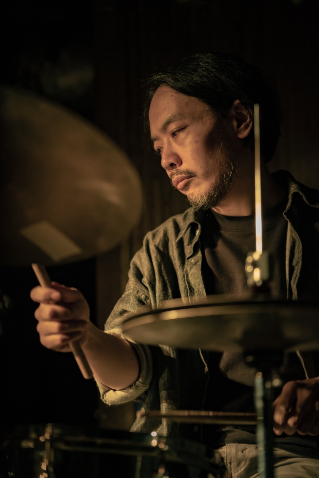 Closeup of Tatsuhisa Yamamoto playing drum kit