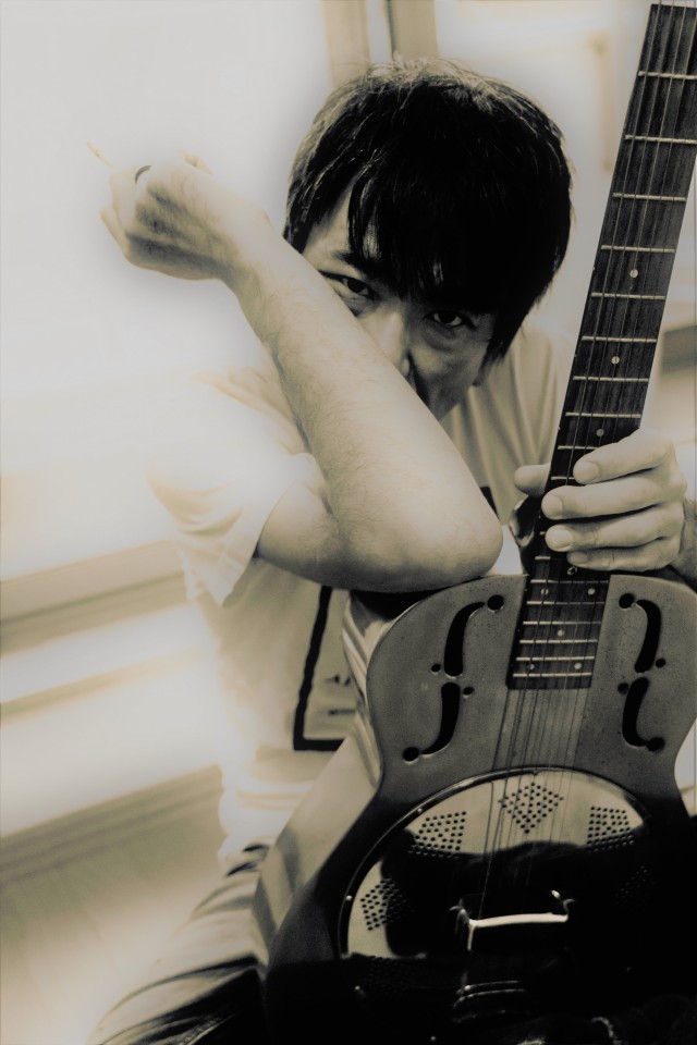 Tetsu Mineta monochrome portrait with resonator guitar